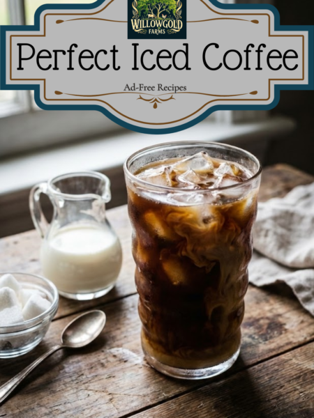 A tall glass filled with ice cubes and dark iced coffee, with condensation on the glass, sitting on a dark wooden table next to a coffee pot and a small pitcher of cream.